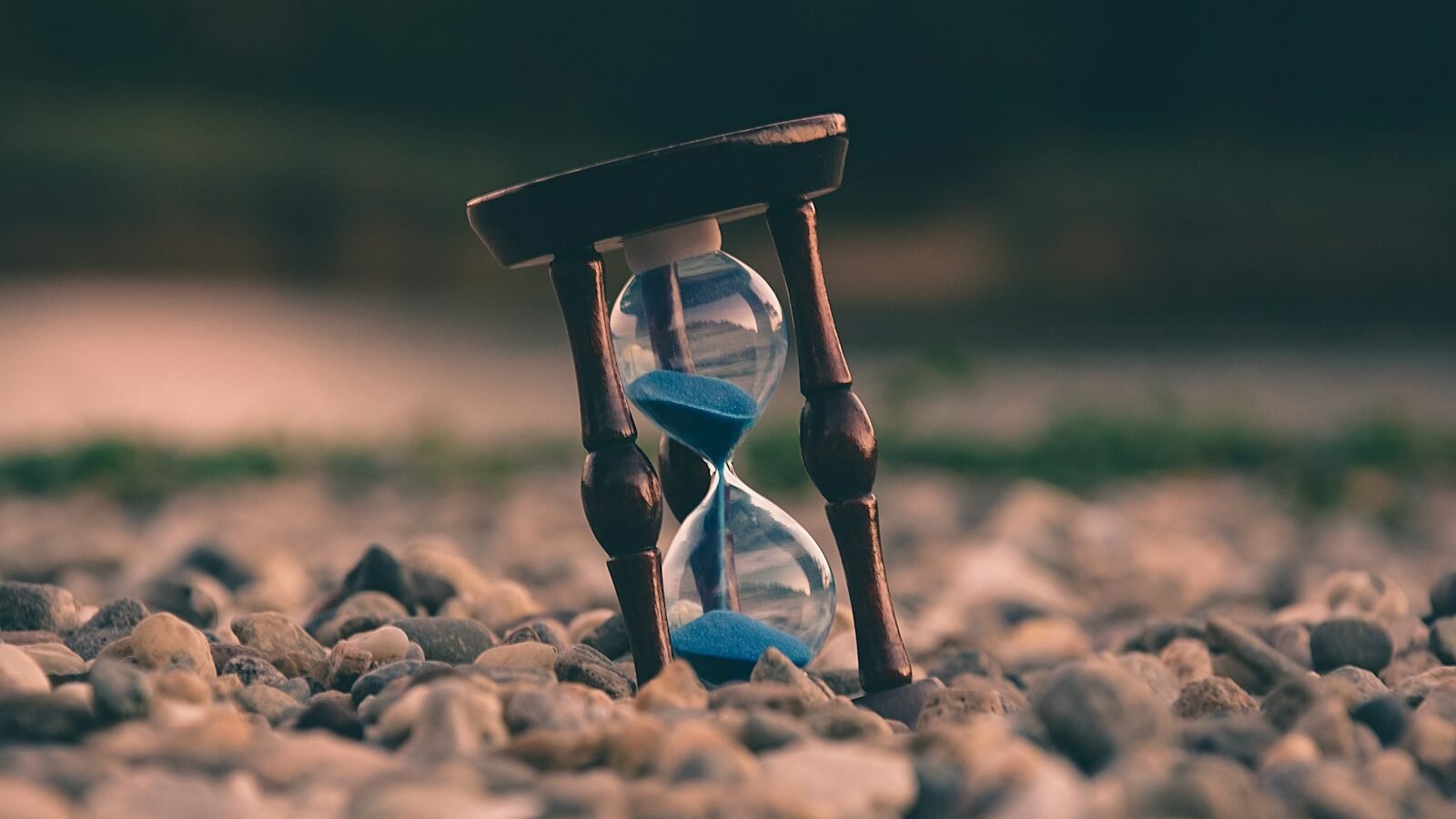 A wall clock beside a notebook on a desk
